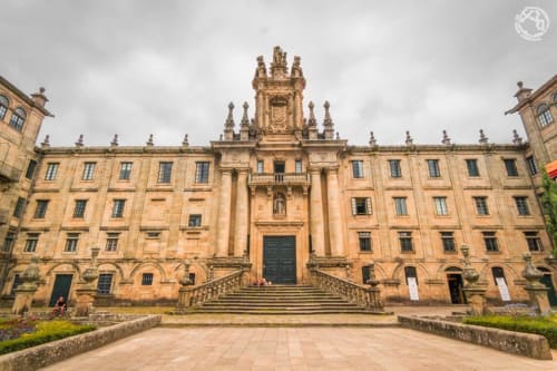 Patio de la Catedral de Santiago de Compostela con arquitectura barroca de piedra dorada y jardines cuidados