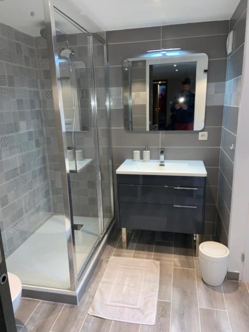 Modern bathroom at Les Edelweiss Mont-Blanc with glass shower, dark vanity, and heated mirror in Passy