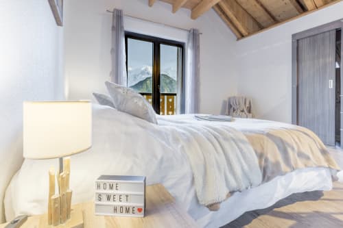 Bright alpine bedroom at Les Edelweiss Mont-Blanc with mountain views, luxury bedding, and cozy lighting