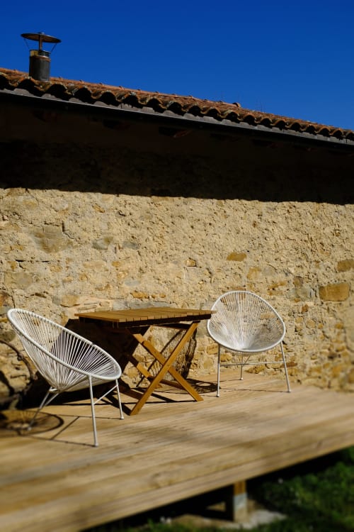 Zona de estar contemporánea en terraza de madera con vistas a muros de piedra rústica en Casa rural MAÑARINEGI, Gipuzkoa