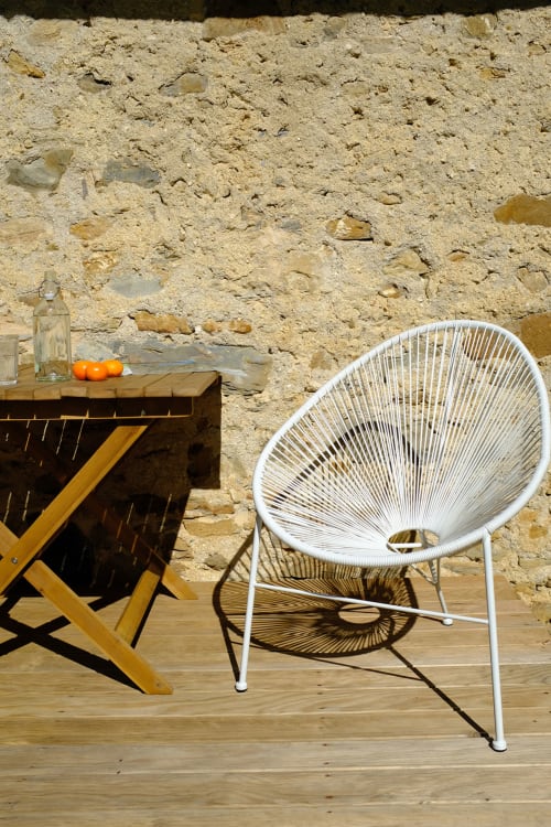 Rústica zona de estar al aire libre con silla tejida blanca y mesa de madera en Casa rural MAÑARINEGI, Gipuzkoa, España