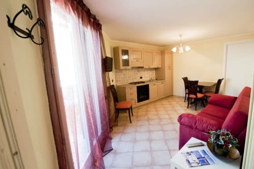 Appartamento open-plan con cucina, zona pranzo e divano rosso presso Residence La Corte a Vezza d'Oglio, Italia