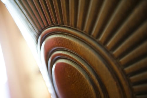 Dettaglio architettonico in legno ornato con design a ventaglio radiante della Residence La Corte
