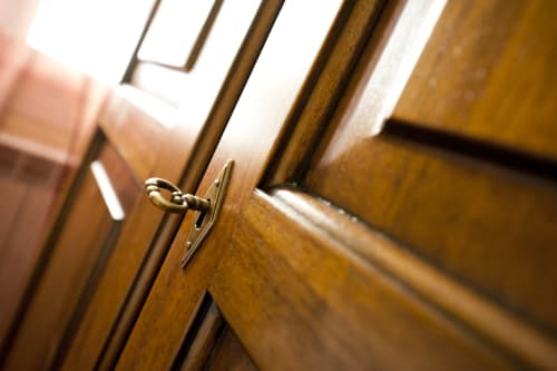 Maniglia in ottone su porta in legno dell'appartamento Residence La Corte, Vezza d'Oglio