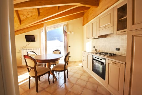 Zona cucina-soggiorno moderna con vista balconata presso Residence La Corte, Vezza d'Oglio