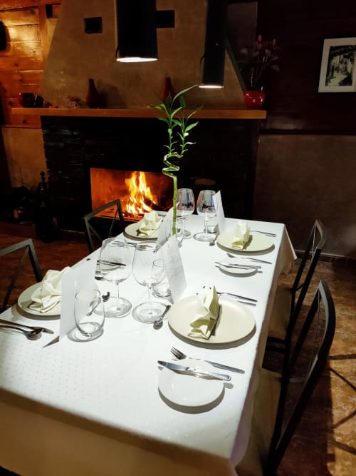 Mesa de comedor elegante junto a la chimenea en el restaurante El Paraje del Chef de Laroles, Granada