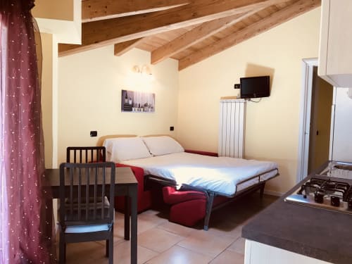 Monolocale Residence La Corte a Vezza d'Oglio con letto, culla, travi a vista, TV e vista città