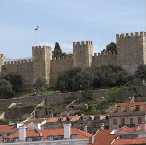 Castelo medieval com torres ameadas dominando construções de telhados vermelhos em Leiria, Portugal