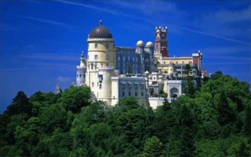 Hotel Palácio de Sintra pousado em encosta cercado por densa floresta verde sob céu azul