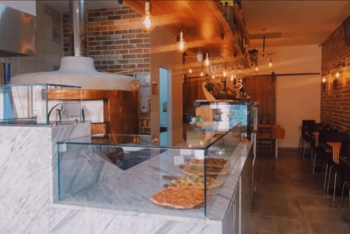 Modern bakery counter at Charm Discovery Experiences B&B in Leiria, Portugal, featuring pastries and warm ambient lighting