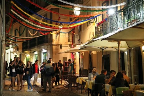 Noite festiva nas ruas de Leiria com decorações coloridas, jantar ao ar livre e hóspedes da Charm Discovery Experiences