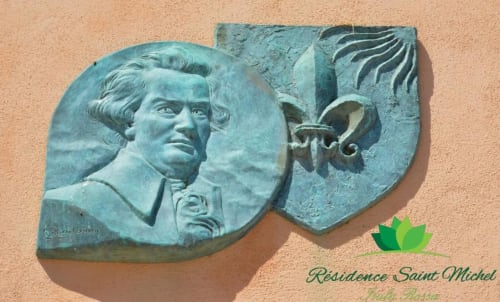 Plaque en bronze en relief à la Résidence Saint Michel, L'île Rousse, Corse, présentant un portrait historique et des éléments décoratifs
