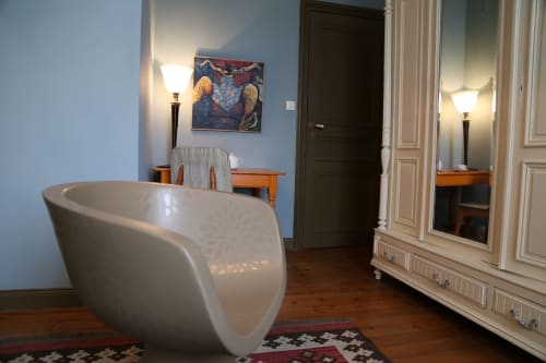 Le Grand Duc bedroom in Valenciennes with modern white chair, wooden furniture, and artwork
