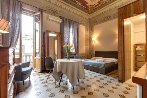 Elegante appartamento a Firenze con soffitto decorato, balcone, tavolo rotondo, letto e arredamento italiano classico presso Sleep tight