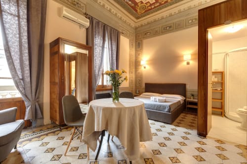 Appartamento lussuoso presso Sleep tight Florence con elegante zona soggiorno, tavolo rotondo, letto e soffitto ornamentale