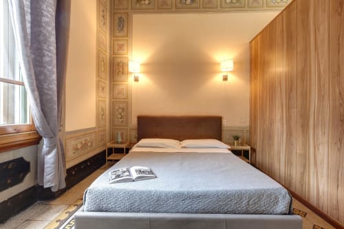 Elegante camera da letto deluxe a Firenze con pareti in legno, testiera marrone e arredamento classico presso Sleep tight