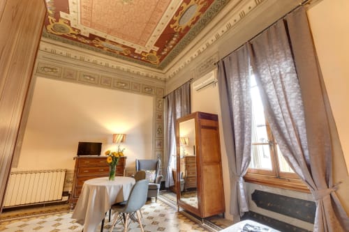 Elegante appartamento deluxe presso Sleep tight Florence con soffitto ornato, arredi in legno e finestre affacciate su Firenze