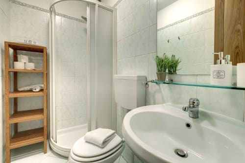 Bagno moderno nell'Appartamento Deluxe Sleep tight Florence a Firenze, con doccia, lavabo, wc e scaffalature in legno
