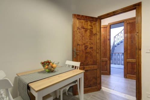 Dining area in Superior Apartment at Sleep tight Florence, with wooden doors opening to balcony