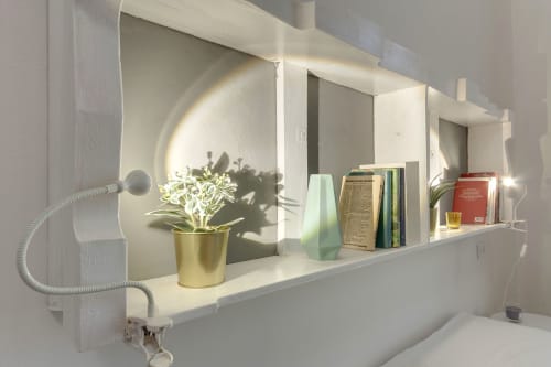 Modern bathroom shelf at Sleep tight Florence with plant, books, and toiletries in white minimalist apartment