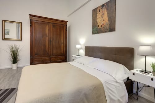 Modern bedroom at Sleep tight Florence BnB in Firenze with queen bed, brown headboard, wooden wardrobe, and garden view