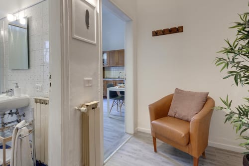 Cozy apartment bathroom and hallway at Sleep tight Florence B&B, featuring brown leather armchair with cushion and modern