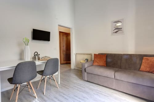 Modern apartment living room at Sleep tight Florence with sofa, desk area, wall TV, and garden views in Firenze