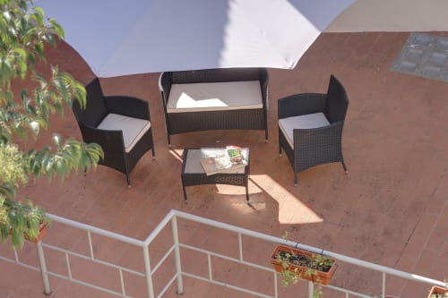 Outdoor seating area on terrace at Sleep tight Florence apartment in Firenze with wicker furniture and garden view