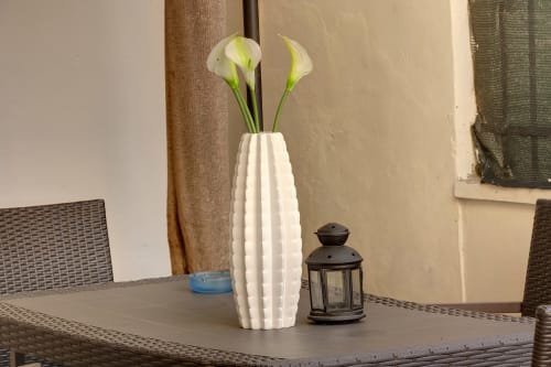 White calla lily arrangement in modern vase on garden apartment table at Sleep tight Florence