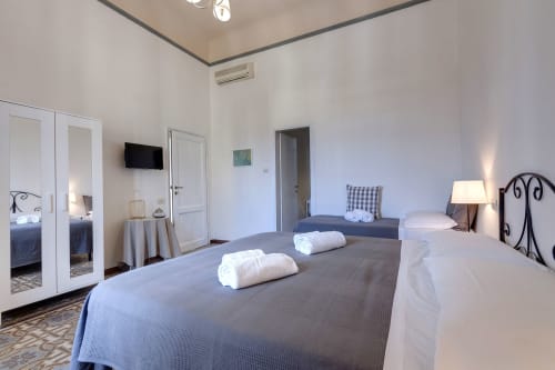 Spacious apartment bedroom at Sleep tight Florence with twin beds, mirrored wardrobe, TV, and modern amenities in Firenze