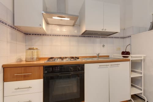 Modern kitchen in One-bedroom apartment at Sleep tight Florence BnB, Firenze, with wooden counters and white cabinets