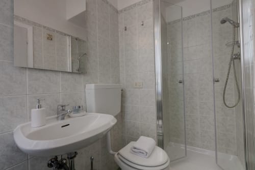 Modern bathroom in Florence apartment with shower, sink, toilet, and mirror at Sleep tight Florence B&B