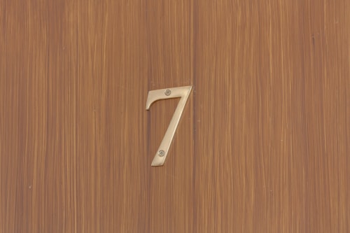 Brass number 7 mounted on wooden door at Sleep tight Florence apartment in Firenze, Italy