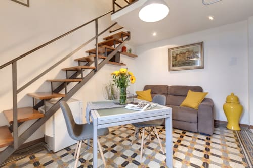 Moderno loft con open space a Sleep tight Florence, scala in legno, scrivania, divano marrone e dettagli gialli