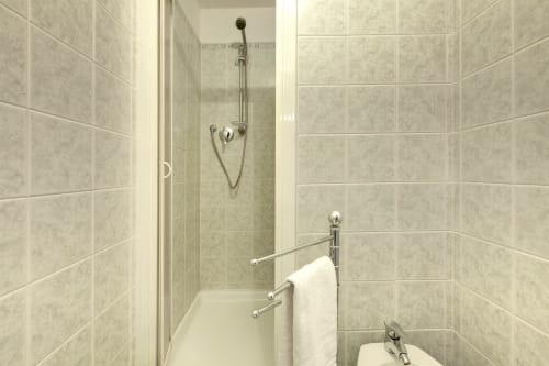 Bagno moderno con doccia in piastrelle e asciugamano bianco nell'appartamento Sleep Tight Florence a Firenze