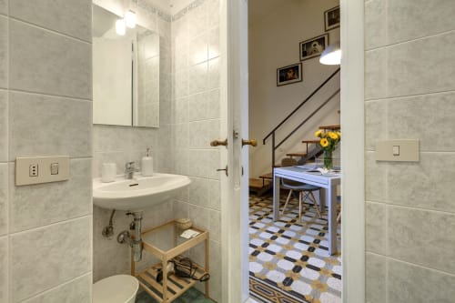 Bagno moderno nell'appartamento loft di Firenze con pareti piastrellate, lavabo, specchiera e vista sulla zona living
