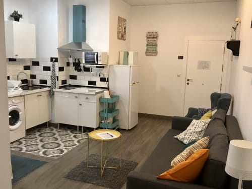 Estudio en Apartamentos Huelintown, Málaga, con cocina, sala de estar, sofá y mobiliario moderno