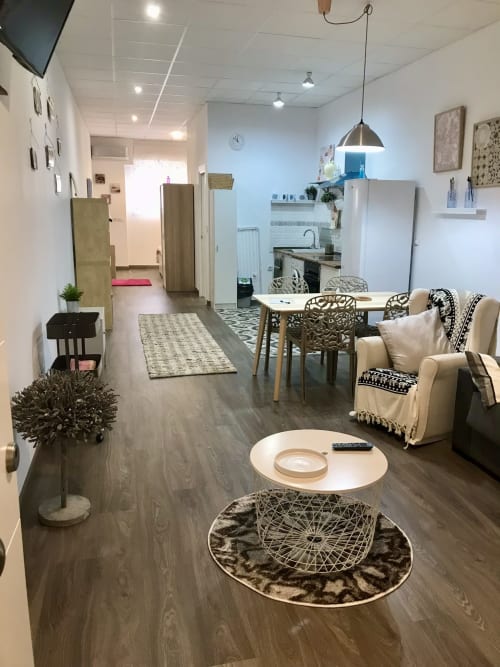 Moderna sala de estar en Apartamentos Huelintown en Málaga con cocina abierta, mesa de comedor, zona de estar y decoración oscura
