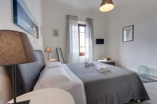 Modern bedroom at Sleep tight Florence with garden view balcony, double bed, desk, TV, and bright natural lighting