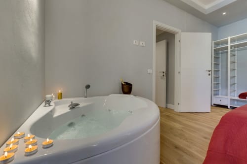 Suite lussuosa con vasca idromassaggio circolare, candele, pavimenti in legno e comfort moderni a Sleep tight Florence