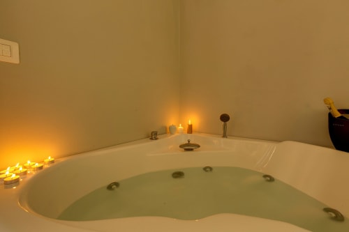 Lussuosa vasca idromassaggio con candele profumate nel bagno della suite Sleep Tight Florence