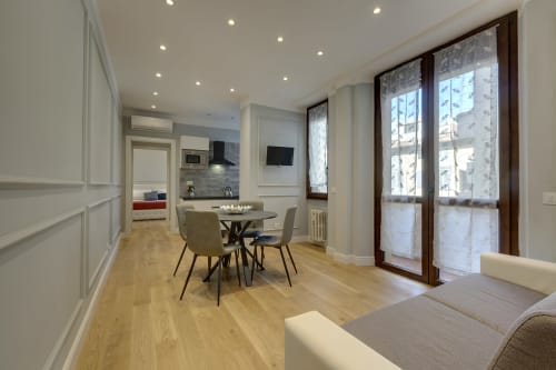 Suite moderna di Firenze con zona pranzo, divano, porte balcone e angolo cottura attrezzato presso Sleep tight