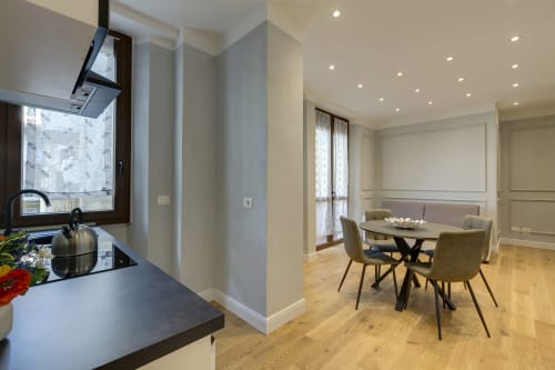 Suite moderna fiorentina con cucina a vista, zona pranzo e balcone con arredi contemporanei e pavimenti in legno