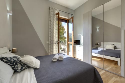 Modern bedroom at Sleep tight Florence with garden view, mirrored wardrobe, and balcony doors in Firenze