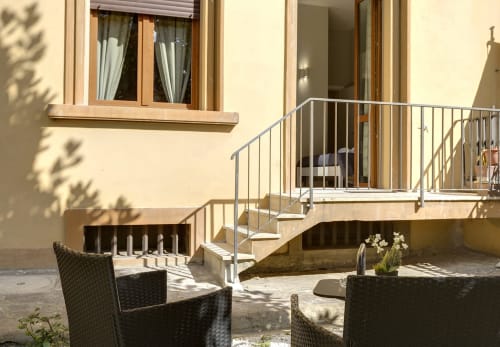 Sleep tight Florence garden view with patio seating, stairs, and modern railings in Firenze