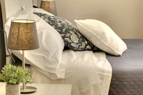 Cozy bedroom at Sleep tight Florence with white linens, decorative pillows, bedside lamp, and garden view in Florence, Italy