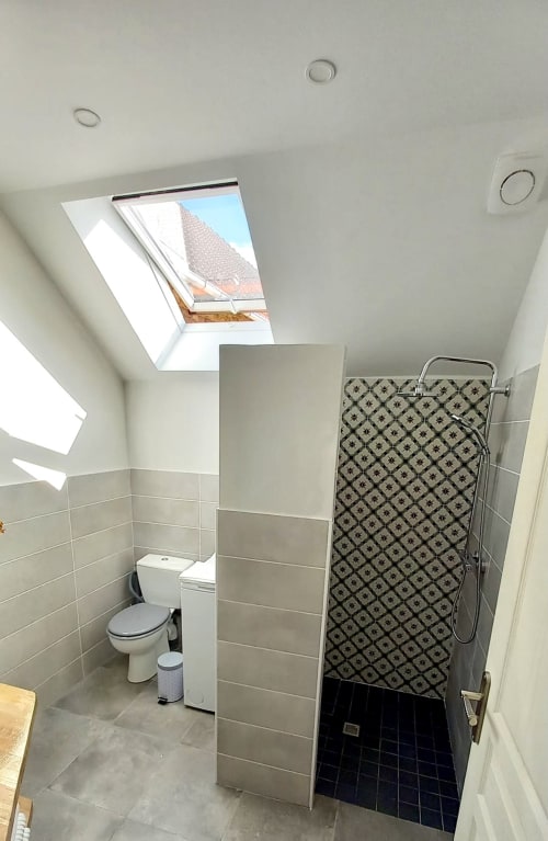 Salle de bain moderne sous les combles à La Maison De Fleurat avec puits de lumière, douche à l'italienne et carrelage géométrique à Domeyrot