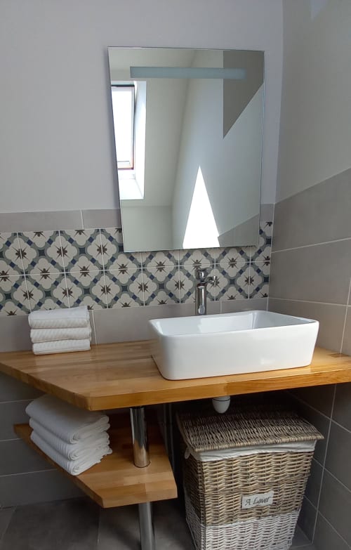 Vasque blanche élégante, plan de travail en bois et carrelage motifs à La Maison De Fleurat