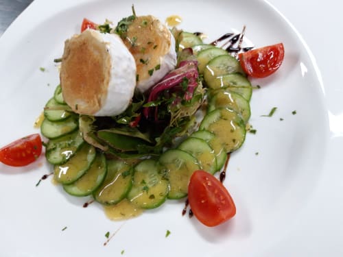 Plato gourmet de El Paraje del Chef con huevo poché, ensalada de pepino y adorno de tomate en Granada