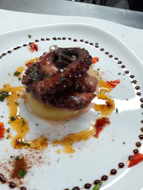 Plato gourmet de El Paraje del Chef en Granada con carnes braseadas, puré y decoración artística de salsas